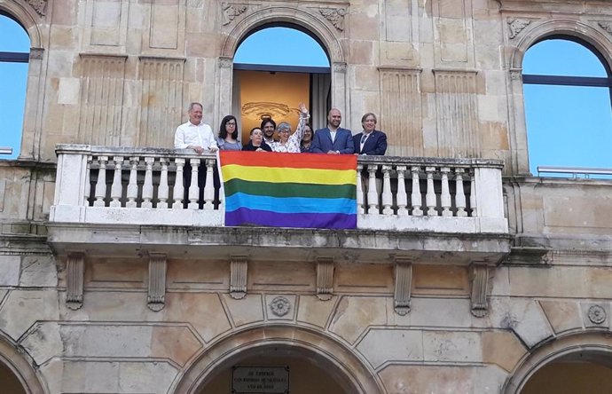 La alcaldesa de Gijón, Ana González, representantes municipales y de Xega descuelgan la bandera arcoíris en el Balcón Municipal, en 2019