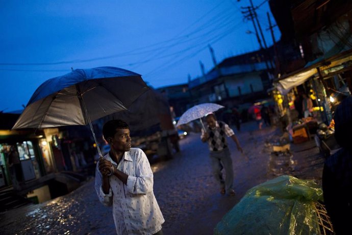 Varias personas en Nepal con paragüas por las lluvias.