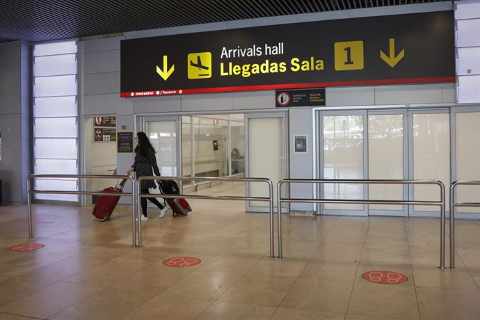 Una persona empuja dos maletas mientras abandona la sala de llegadas 1 de la Terminal 1 del Aeropuerto de Barajas, en Madrid (España) a 4 de julio de 2020.