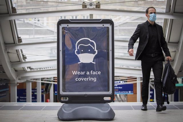 Cartel que promueve el uso de mascarilla en una estación de Edbimburgo