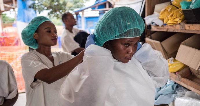 Dos mujeres se visten con equipos de protección durante el brote de ébola en R.D. del Congo