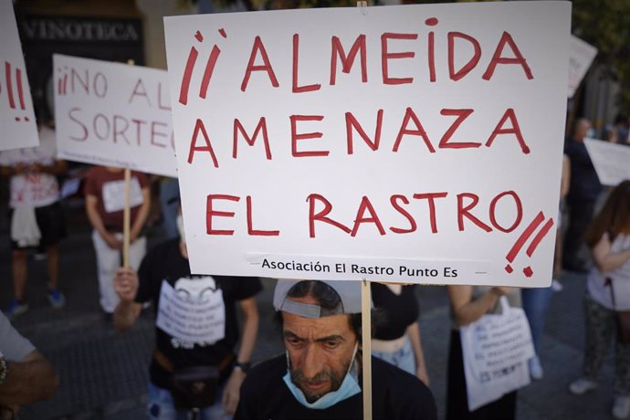 Un hombre lleva un cartel en el que se lee '¡¡Almeida amenaza El Rastro!!', durante la concentración para denunciar que El Rastro está "amenazado" bajo el lema 'Por la reapertura ya del Rastro de Madrid respetando a todos y cada uno de los titulares de 