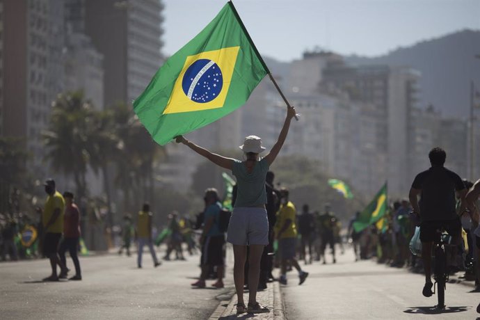 Una mujer con una bandera de Brasil.