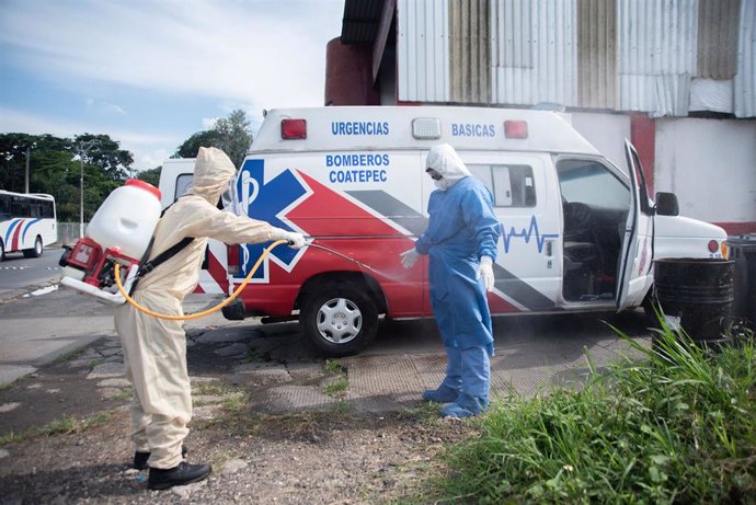 Dos trabajadores sanitarios desinfectándose por el coronavirus en México. 