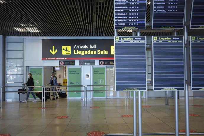 Personas abandonan una de las salidas de la sala de llegadas de la Terminal 1 del Aeropuerto de Barajas, en Madrid (España) 