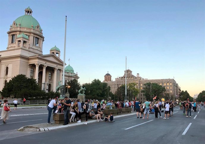 Imagen de varios manifestantes frente al Parlamento de Serbia. 