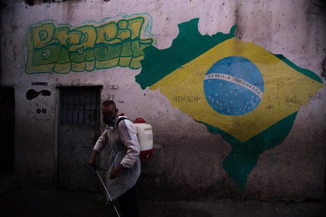 Imagen de un hombre desinfectando una favela en Sao Paulo por el coronavirus. 