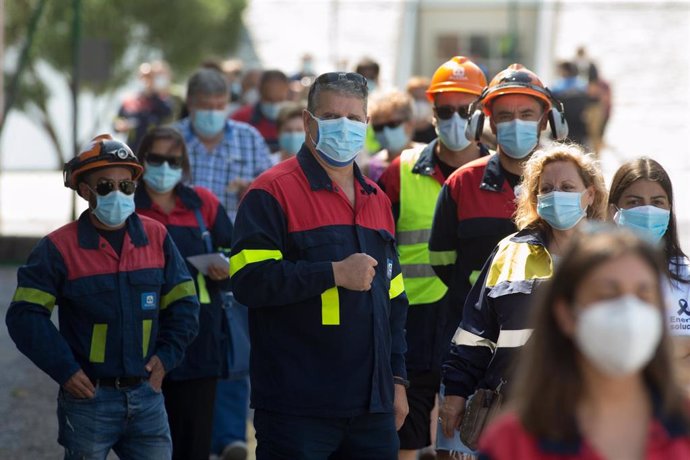 Traballadores de Alcoa ataviados co uniforme da fábrica acoden a votar nas eleccións autonómicas de Galicia no Pavillón Vos Castros, en Burela