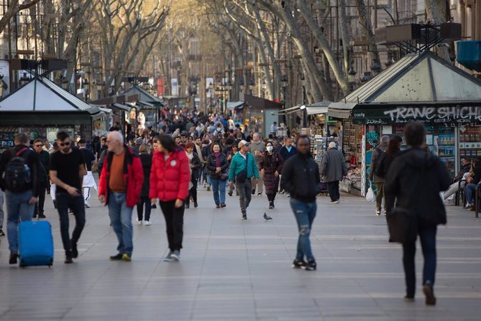 Varias personas caminan por las Ramblas de Barcelona, ciudad en la que, a pesar de haberse reducido, el turismo no ha caído tanto como en Madrid, donde los efectos del coronavirus han sido más letales, en Barcelona (Catalunya, España), a 13 de marzo de 