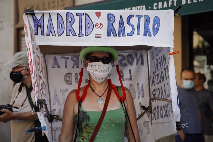 Una mujer lleva un cartel en el que se lee 'Madrid es Rastro', durante la concentración para denunciar que está "amenazado" bajo el lema 'Por la reapertura ya del Rastro de Madrid respetando a todos y cada uno de los titulares de los puestos de venta'.