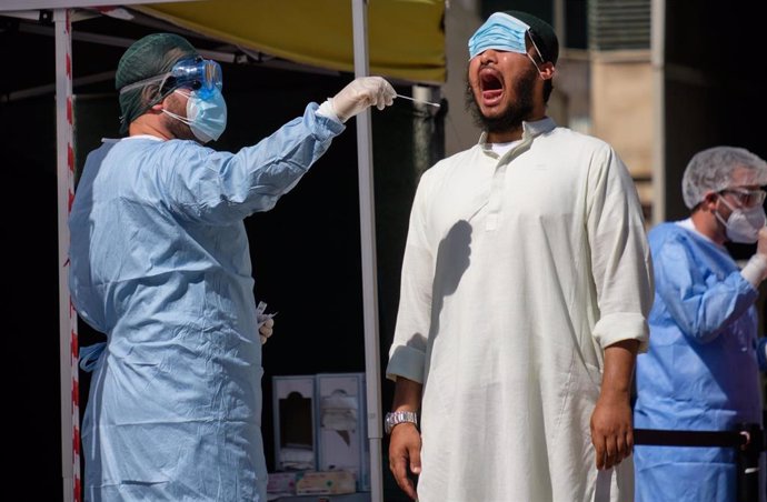 Un trabajador sanitario toma una muestra a un miembro de la comunidad bangladeshi en Roma