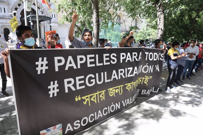 Varias personas sostienen una pancarta donde se puede leer "Papeles para todos, regularización" durante una manifestación de las entidades ciudadanas que están dando respuesta a las 'colas del hambre' ante el Palacio de Cibeles