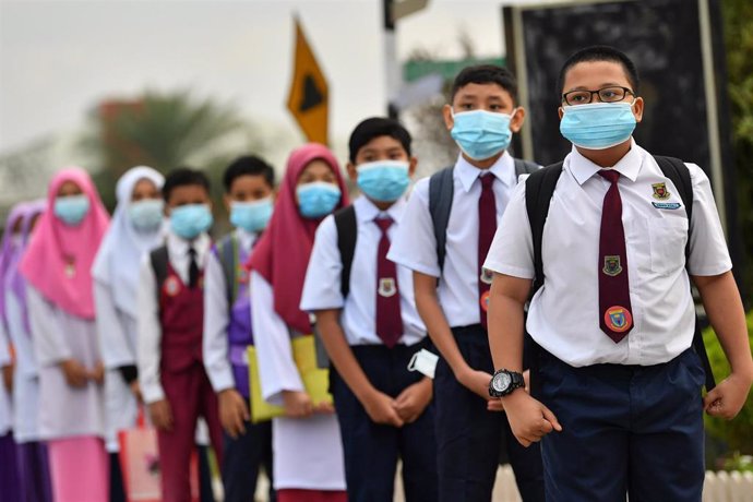 Alumnos de un colegio de la localidad malasia de Ipoh hacen cola paa que les tomen la temperatura