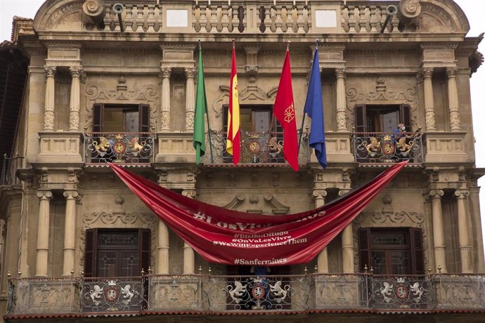 Recogida de la lona con forma de pañuelo rojo instalada en la fachada del Ayuntamiento de Pamplona el 6 de julio