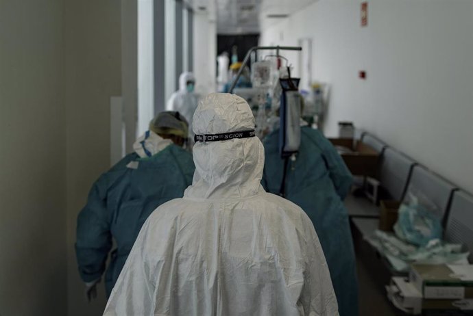 Personal sanitario totalmente protegido trasladan a un paciente ingresado en la Unidad de Cuidados Intensivos del Hospital Infanta Sofía en San Sebastián de los Reyes (Madrid), a 28 de abril de 2020.