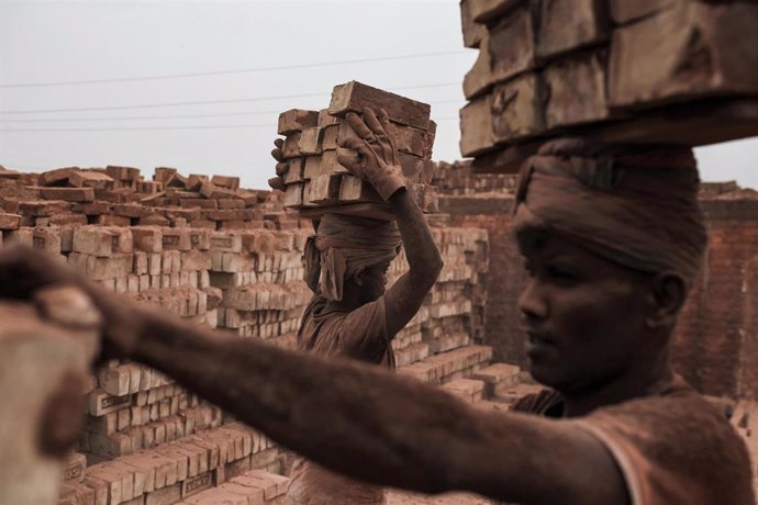 29 April 2020, Bangladesh, Dhaka: Migrant labourers carry brick on their heads at a local brick factory in Dhaka. Photo: Md Mehedi Hasan/ZUMA Wire/dpa