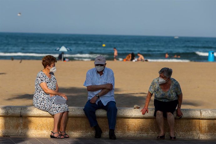 Tres ancianos descansan en el paseo marítimo de la playa de la Malvarrosa durante la fase 2 de la desescalada en la pandemia de coronavirus COVID19. En Valencia, España, a 3 de junio de 2020.