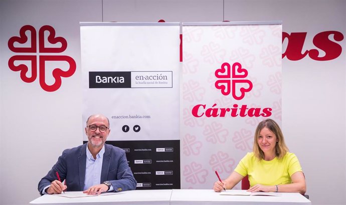 El director de Gestión Responsable de Bankia, David Menéndez, y la secretaria general de Cáritas Española, Natalia Peiro, firman el acuerdo por el que Bankia apoya con 200.000 a la organización de la Iglesia