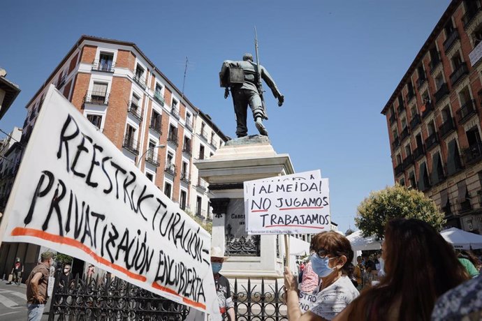 Una mujer sostiene un cartel en el que se lee '¡Almeida! No jugamos, trabajamos', durante la concentración para denunciar que El Rastro está "amenazado", en la Plaza Cascorro, en Madrid (España) a 5 de julio de 2020.