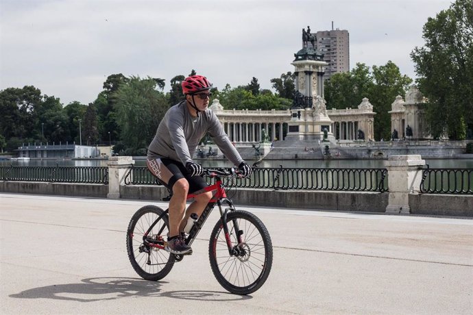 Un hombre monta en bicicleta por el Parque de El Retiro después de su reapertura.
