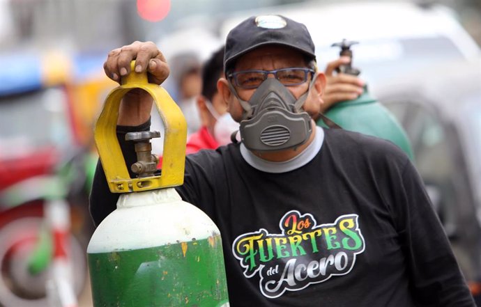 Un hombre con mascarilla espera para rellenar su botella de oxígeno en Perú en plena pandemia del coronavirus. 