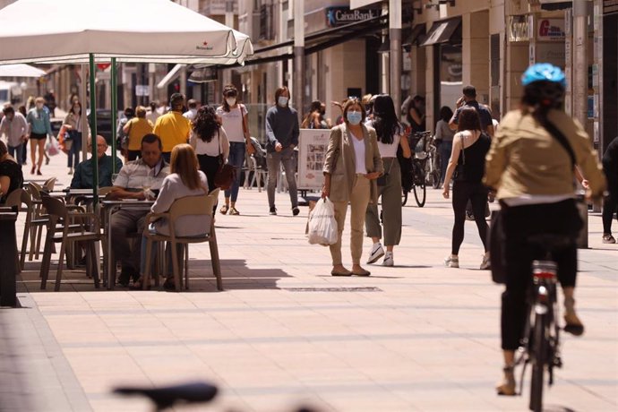 Personas paseando con mascarillas y sentadas en terrazas en una céntrica calle de Vitoria-Gasteiz, Álava, País Vasco (España).