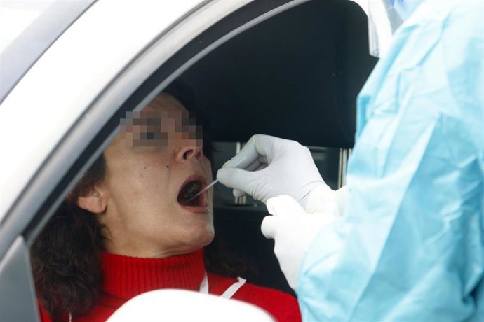 Un sanitario realiza una prueba PCR a una mujer.