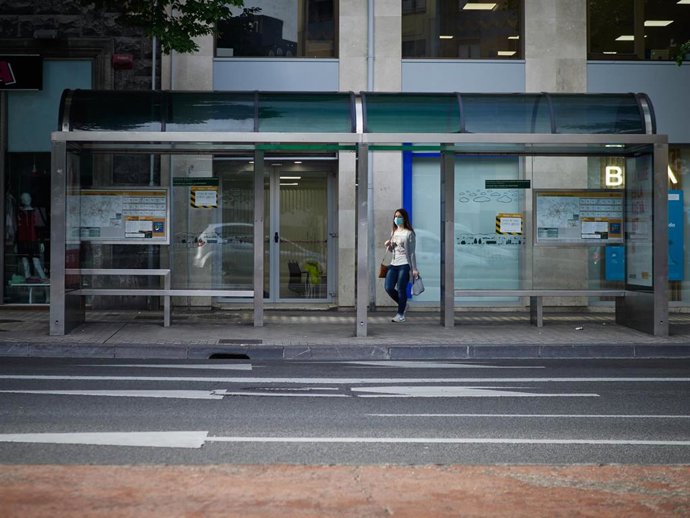 Una mujer con mascarilla para protegerse del coronavirus espera al autobús durante el día 54 del estado de alarma en Pamplona / Navarra (España), a 7 de mayo de 2020.