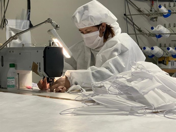 Una trabajadora de la empresa Carpas Zaragoza e Ingeniería Textil elabora material sanitario