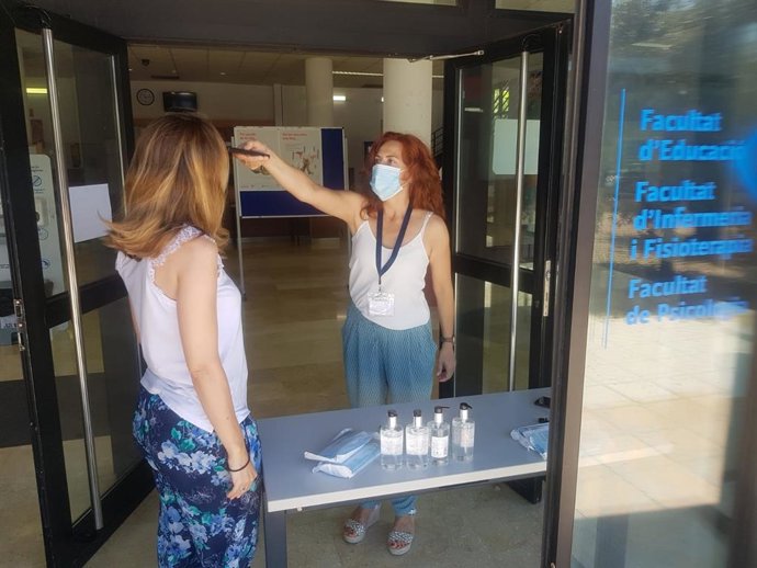 Toma de temperatura a una de las participantes en las pruebas, antes de acceder al recinto.