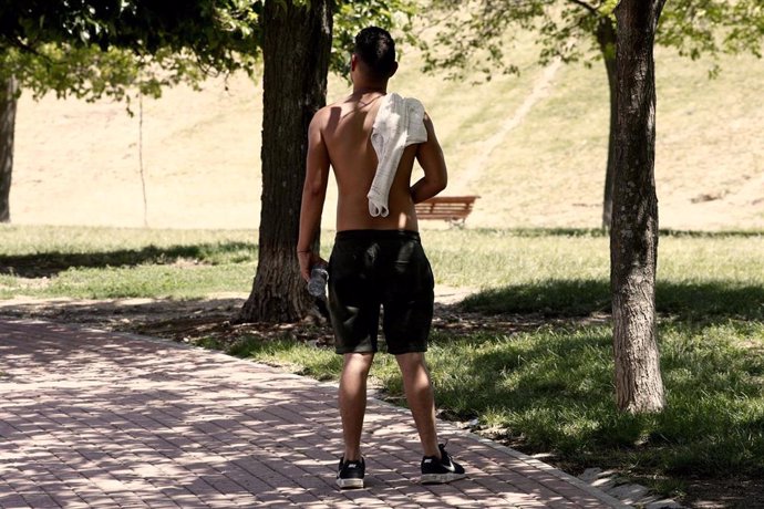 Un joven pasea sin camiseta por el parque de las 'Siete Tetas' de Vallecas (Madrid)