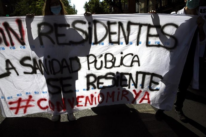 Varios sanitarios sostienen una pancarta en la que se lee 'Sin residentes la sanidad pública se resiente' durante una manifestación.