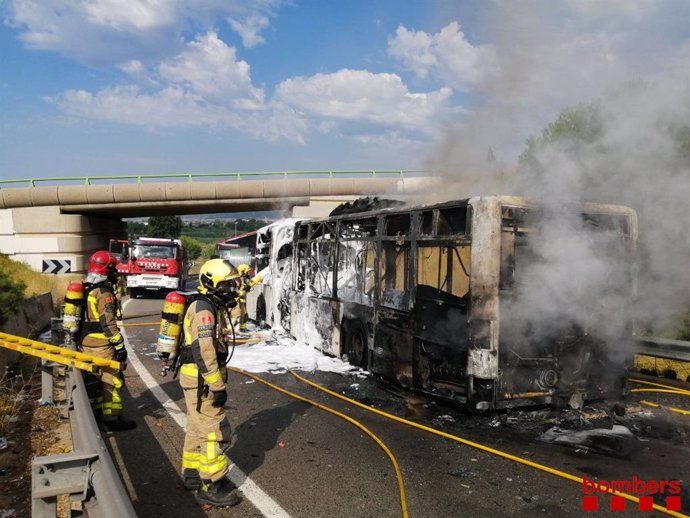 Els Bombers de la Generalitat apaguen un autobús sense passatgers que s'ha incendiat aquest dilluns a la C-32 a l'altura de Cornell de Llobregat (Barcelona)