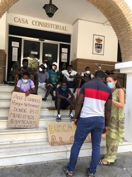 Imagen de algunos de los afectados por los incendios de los asentamientos, concentrados en la puerta del Ayuntamiento de Lepe.