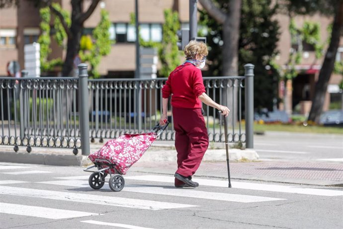 Una anciana con el carrito de la compra en el primer día en que los españoles pueden salir de casa a pasear y hacer ejercicio al aire libre
