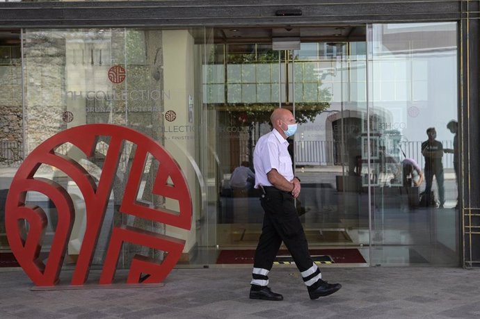 Un trabajador de seguridad camina cerca de la puerta del hotel NH Finisterre de A Coruña donde los jugadores del CF Fuenlabrada permanecen confinados en él tras haber dado positivo en coronavirus varios de sus miembros