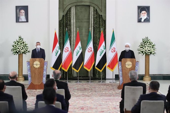 El primer ministro de Irak, Mostafá al Kazemi (i), junto al presidente de Irán, Hasán Rohani (d), durante su visita a Irán