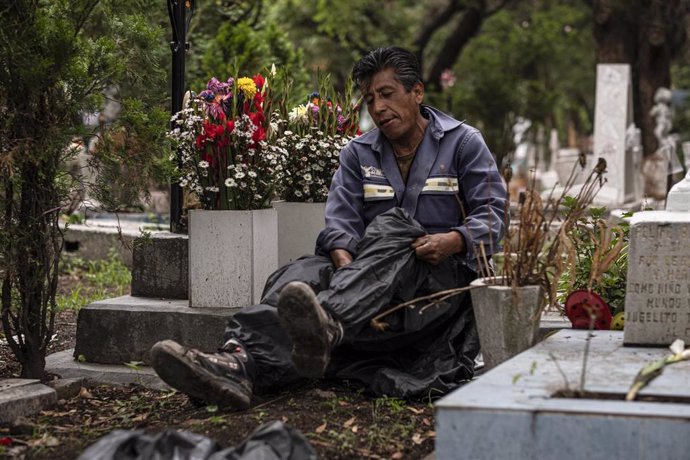 Un empleado de un cementerio en ciudad de México se dispone a enterrar a una persona que ha fallecido a causa de la COVID-19. 