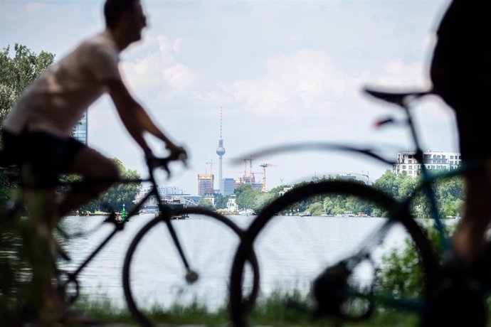 Dos ciclistas circulan por la orilla del río Esprea en Berlín