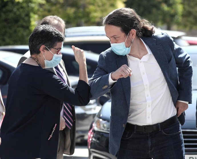 La ministra de Asuntos Exteriores y Cooperación, Arancha González Laya, saluda con el codo al vicepresidente segundo del Gobierno, ministro de Derechos Sociales y Agenda 2030, Pablo Iglesias,  antes de intervenir ambos en la ponencia La centralidad del