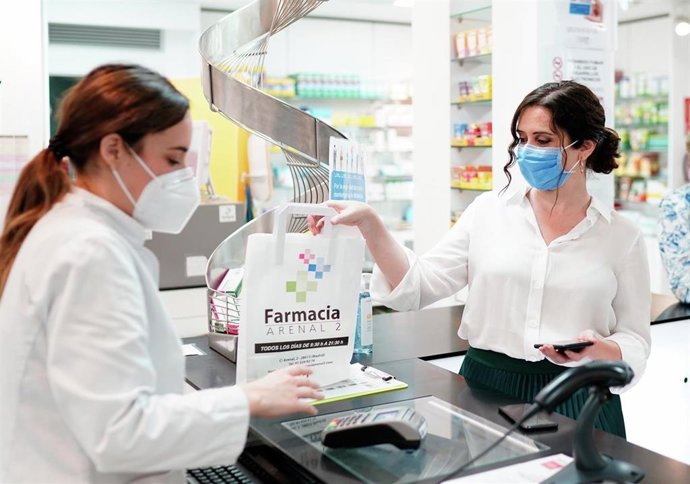 La presidenta de la Comunidad de Madrid, Isabel Díaz Ayuso, durante la visita a una oficina de farmacia para presentar la tarjeta sanitaria virtual en la región.