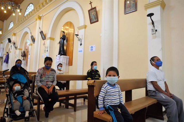 Personas con mascarilla en una iglesia de Quito durante la pandemia de coronavirus en Ecuador