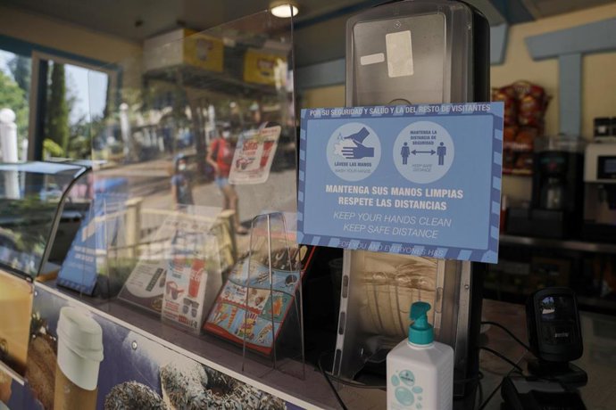 Un cartel indica las medidas de seguridad e higiene junto a una tienda 