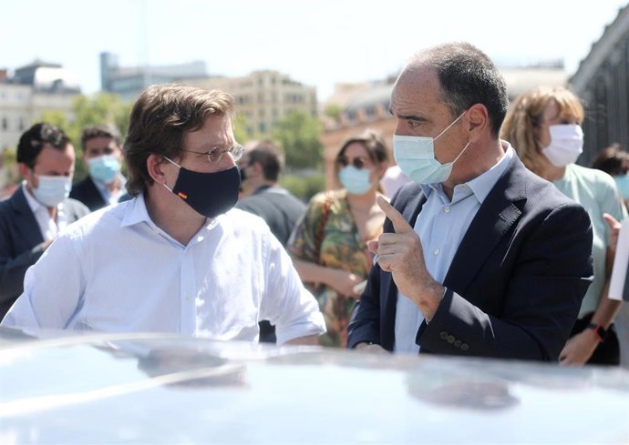 El alcalde de Madrid, José Luis Martínez-Almeida (i), mantiene una conversación durante el acto de comprobación del funcionamiento de la primera papelera inteligente que se coloca.