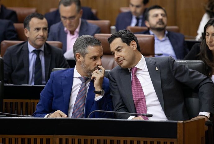 El presidente de la Junta Juanma Moreno (d) junto al consejero de Hacienda, Industria y Energía, Juan Bravo (i).