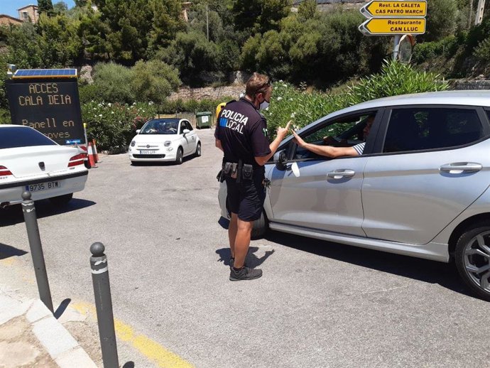 Un agente da instrucciones a un conductor en el acceso a cala Dei.