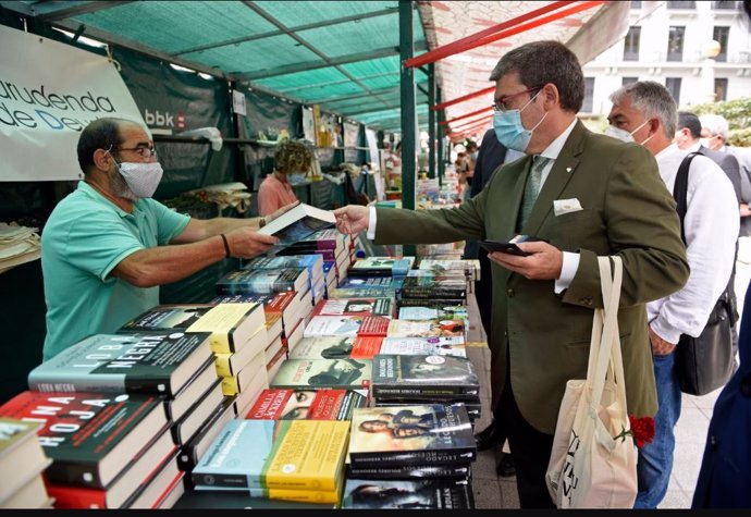 El alcalde de Bilbao, Juan Mari Aburto, compra libros en las casetas instaladas para celebrar del Día del Libro