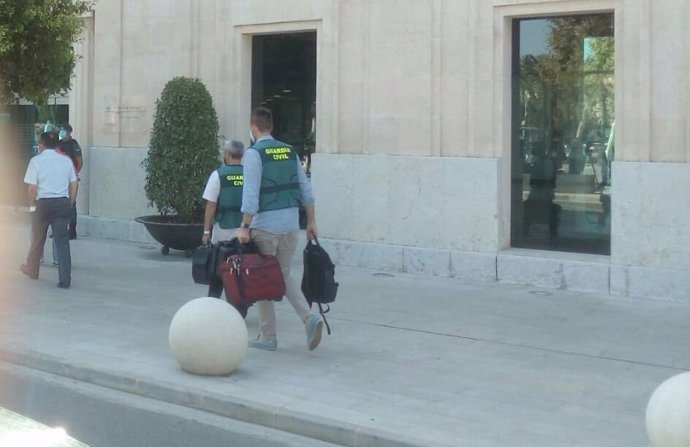 Agentes de la Guardia Civil entran con maletas a la sede de la APB de Palma durante un registro