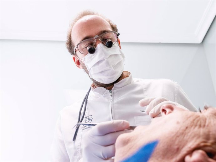 Un dentista atiende a un paciente tras la cuarentena.