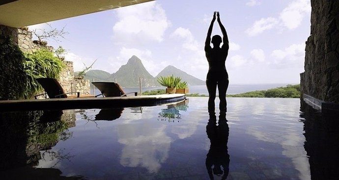 Persona haciendo yoga en una piscina de un hotel.